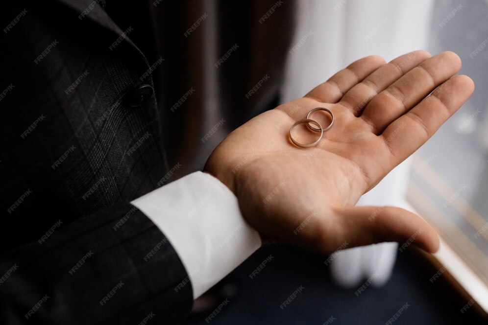 groom holds his palm two wedding rings 8353 10241