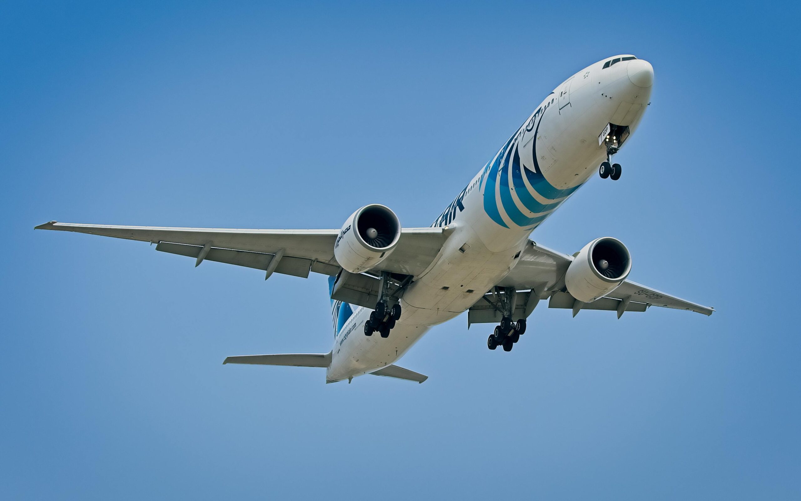 EgyptAir Boeing 777 flying against the clear blue sky over New York City.