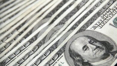 Detailed image showing a close-up of neatly stacked US dollar bills, ideal for financial and economic themes.
