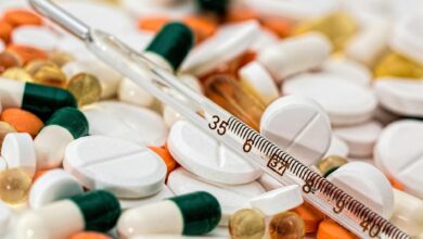 Close-up image showing various pills and a thermometer, emphasizing health and medicine.